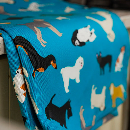 Blue tea towel with dogs pattern, including draped over a kitchen cabinet