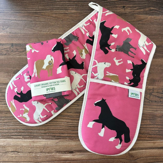 Bright Pink Horses illustrations organic cotton tea towel and matching oven gloves on a wooden counter