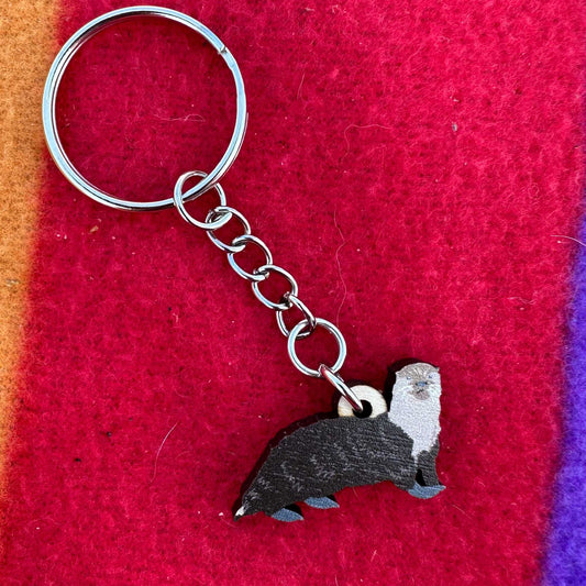 Keychain with an otter design on a red fabric background