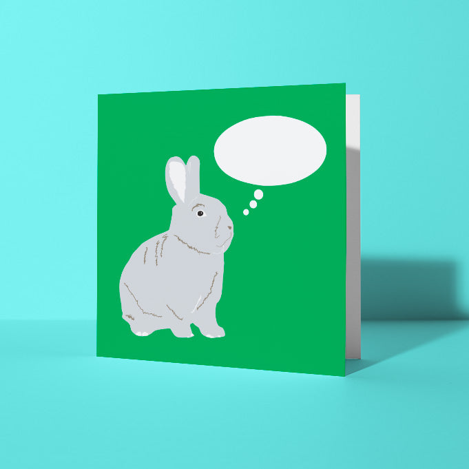 Green greetings card with a rabbit illustration and thought bubble shown on a light blue background