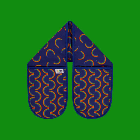 Bright, joyful rainbow stripe oven gloves in a rich deep blue shown on a plain green background