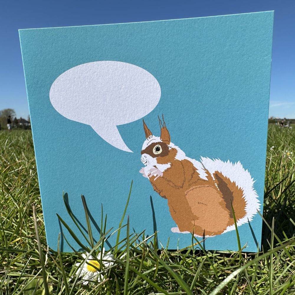 Card with a squirrel illustration shown outside on a grassy park