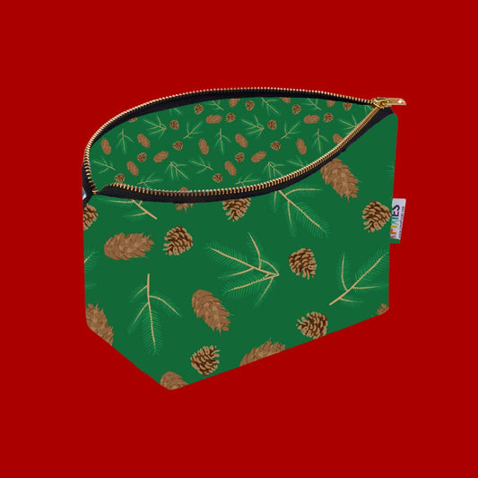 Green Really Useful Bag covered in fir and spruce cones and sprigs shown with zip open to reveal printed coordinating lining