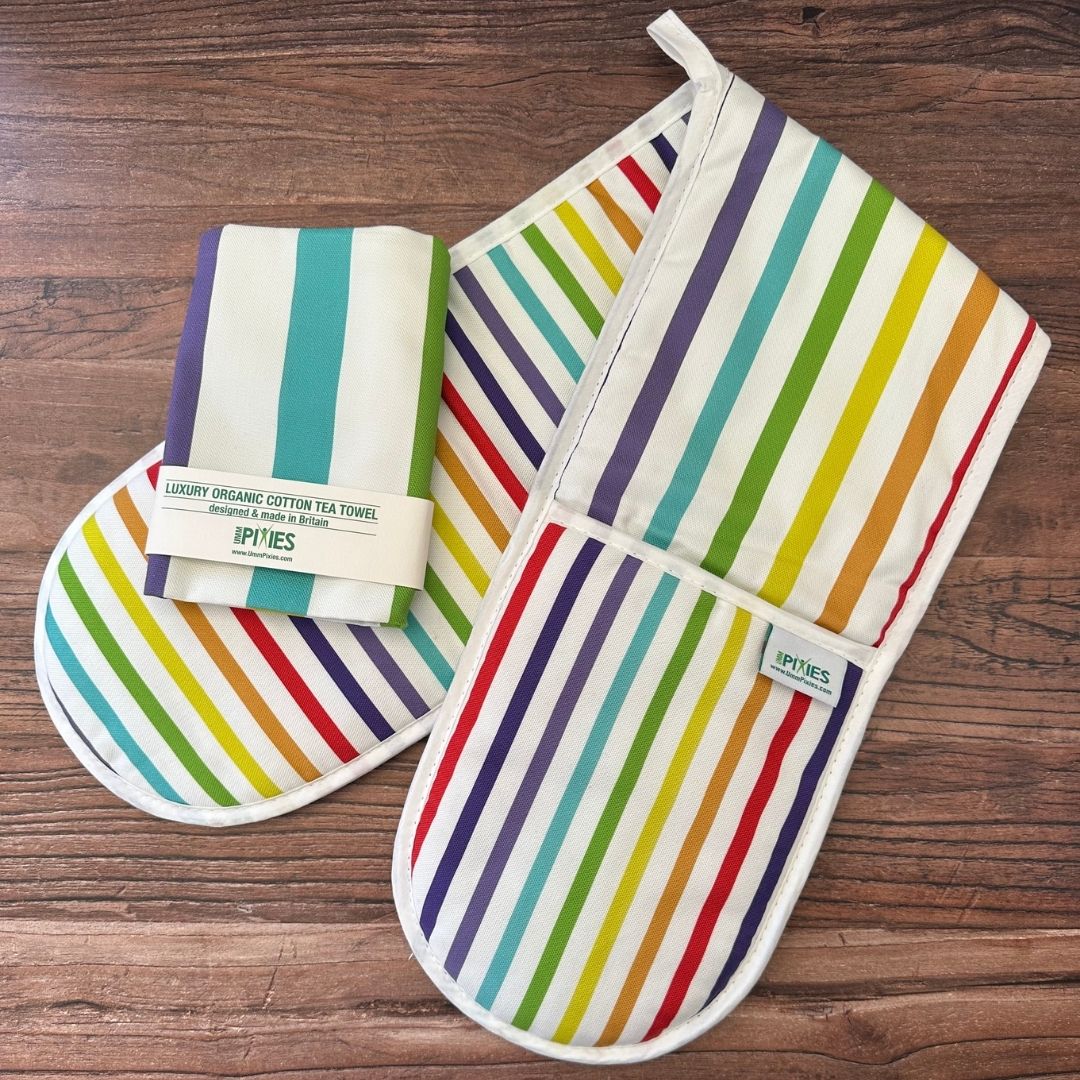 wide rainbow stripe oven gloves with matching tea towel on wooden counter