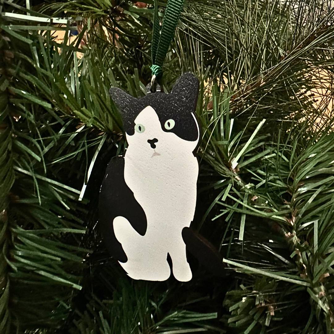 Black and white cat-shaped ornament on a Christmas tree