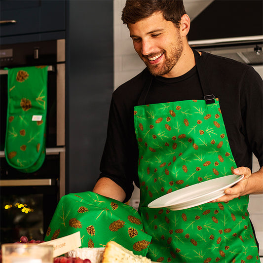 male models the cones apron and Tea towel and the oven gloves are visible in the background