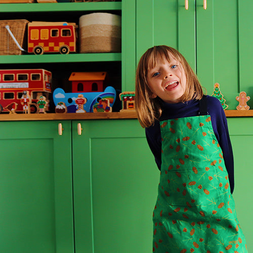 Green Cones and Pine Design Organic Cotton Apron , model wears younger child size, photo credit: @rachelandthelittlebirds