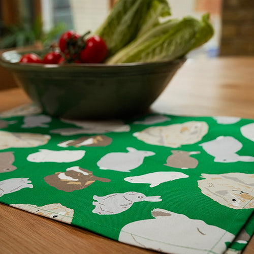 Green Rabbit design organic cotton tea towel shown next to salad bowl