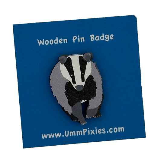 Wooden badger pin badge shown on display card