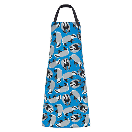 Blue organic Cotton apron featuring badgers illustrations by Ummpixies - shown as worn with pattern matched pocket and black cotton straps with adjustable neck buckle 