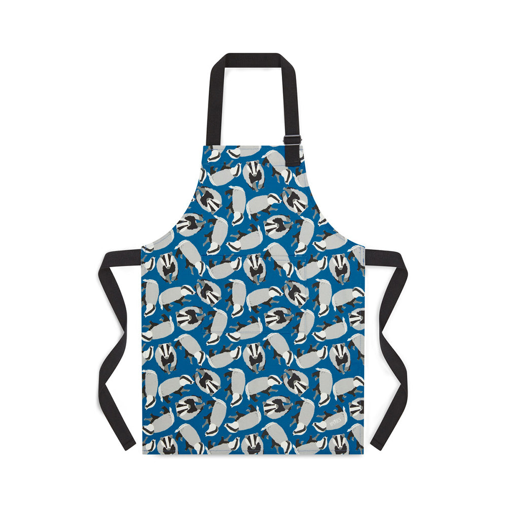 Blue organic Cotton apron featuring badgers illustrations by Ummpixies - shown as worn with pattern matched pocket and black cotton straps with adjustable neck buckle  - younger child size shown suitable for up to 5 years