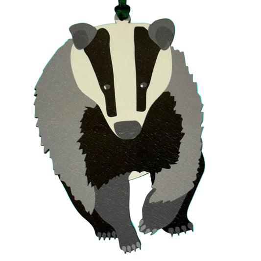 Badger-shaped hanging wooden decoration with a green ribbon 