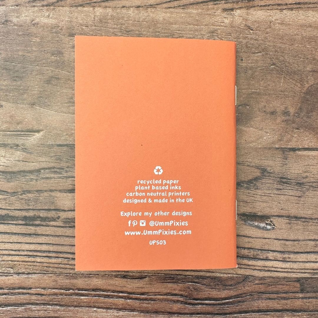 Orange notebook with text on a wooden surface