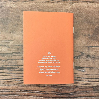 Orange notebook with text on a wooden surface