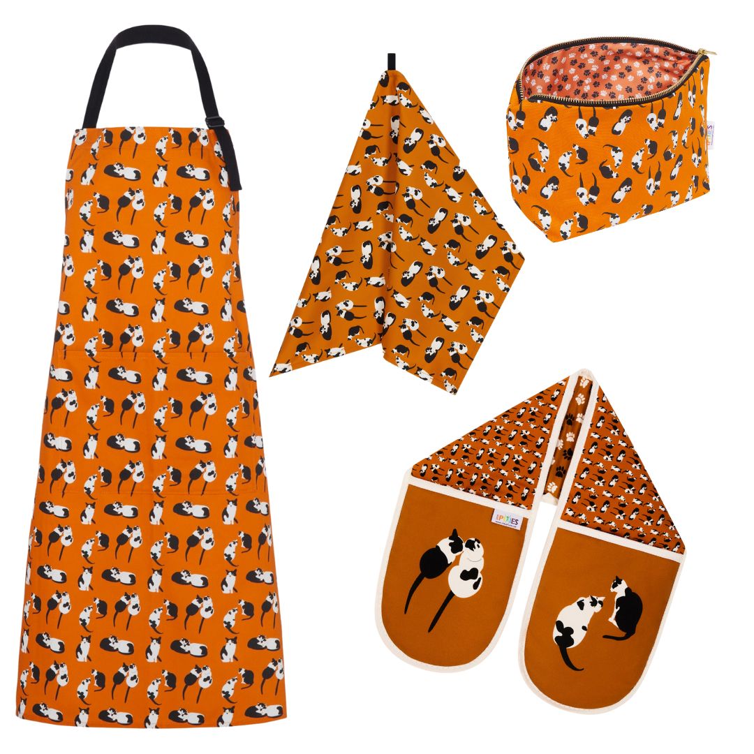 Orange organic cotton kitchen home textiles featuring UmmPixies monochrome moggiesblack and white cat design. Includes oven gloves, tea towel, apron and really useful bag