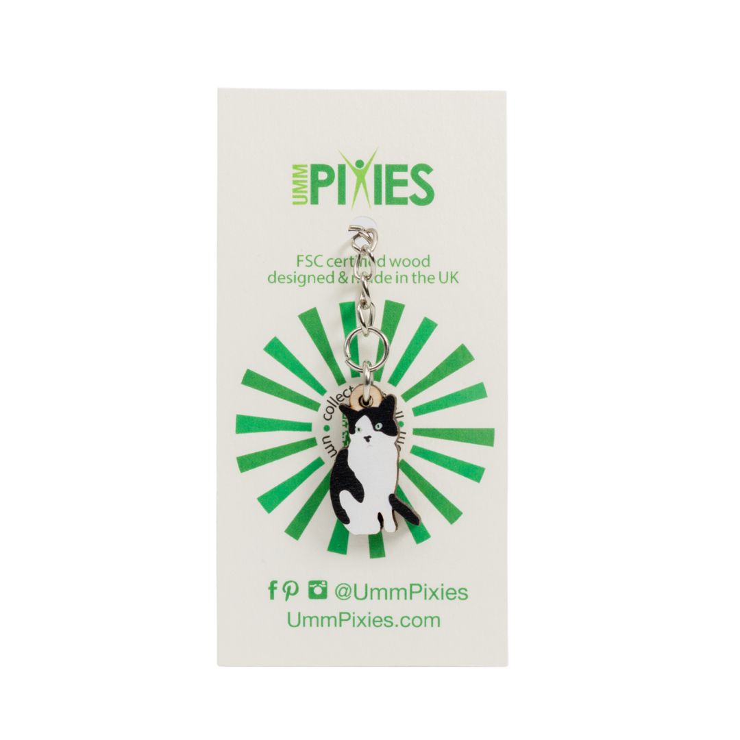 Umm Pixies black and white tuxedo cat wooden keychain on a branded card with green and black design