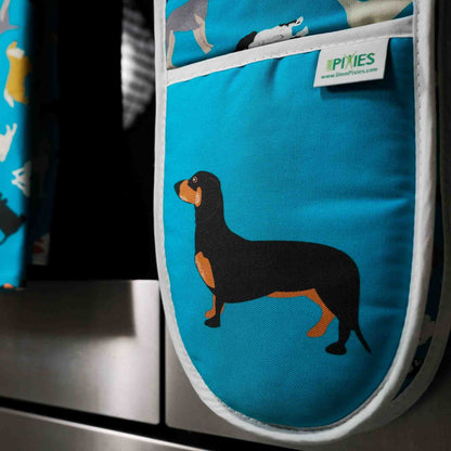 Blue oven mitt with dachshund design hanging on a stove handle