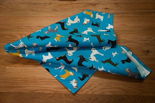 Petrol blue tea towel with dog design on wooden table