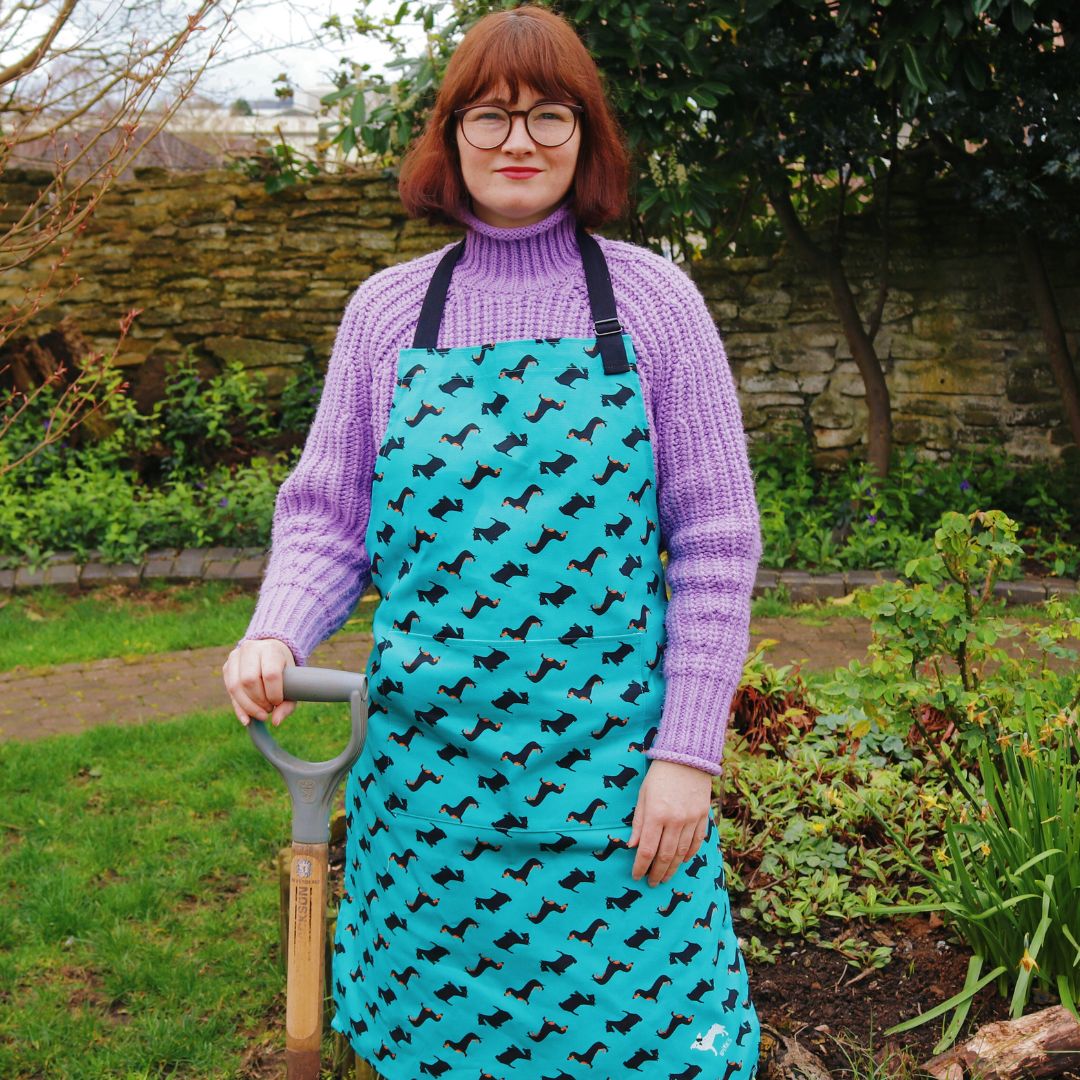 Adult wearing apron whilst gardening Photo credit: @rachelandthelittlebirds