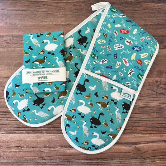 ducks oven gloves and matching tea towel on wooden counter
