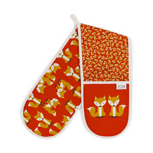 bright red colourful organic cotton oven mitts illustrated with a bold design showing a parade of foxes on one side and a scatter of tiny foxes on the other. The main glove mitt features a pair of sitting foxes. shown here on a plain white background