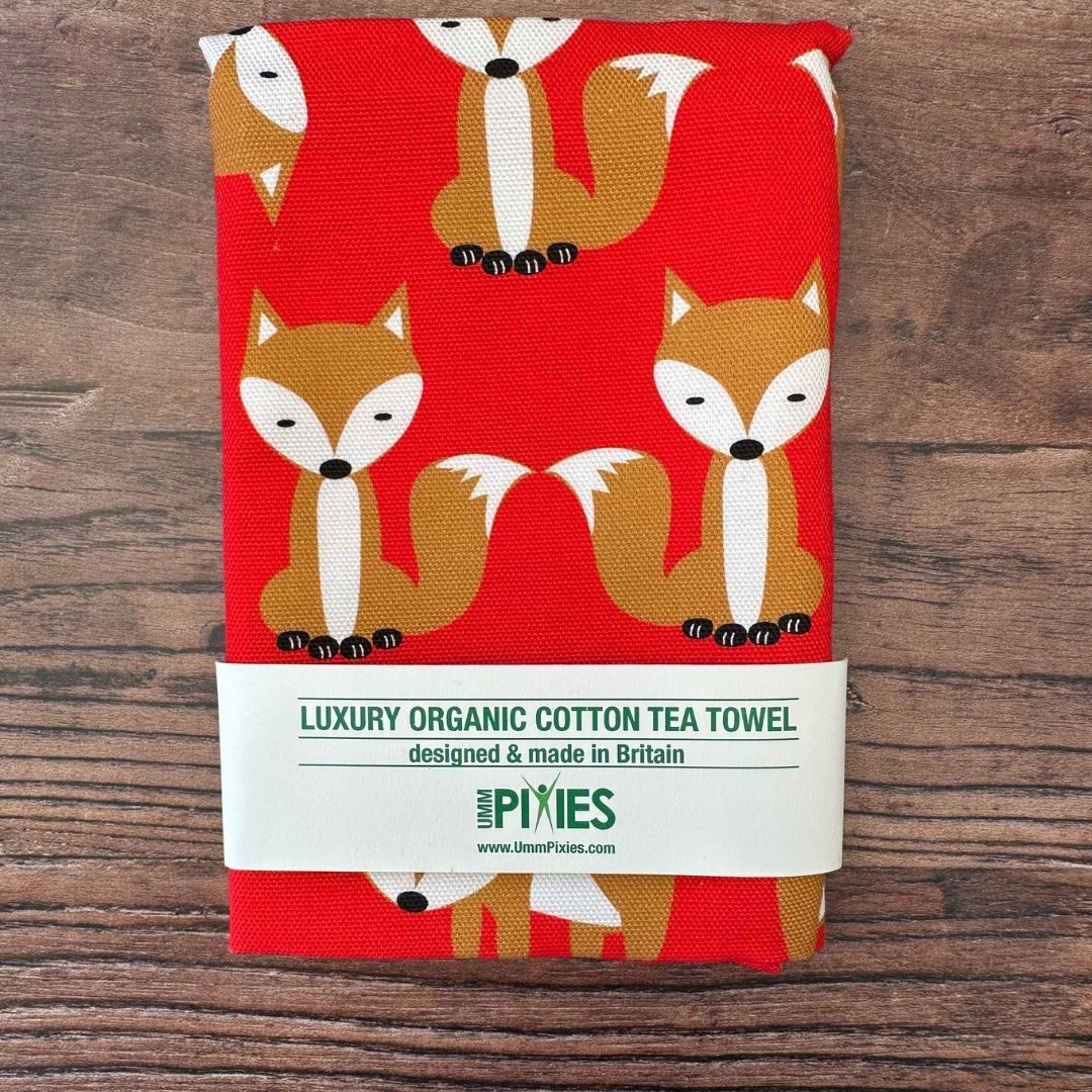 Luxury organic cotton tea towel with fox pattern on a wooden surface