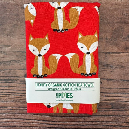 Luxury organic cotton tea towel with fox pattern on a wooden surface
