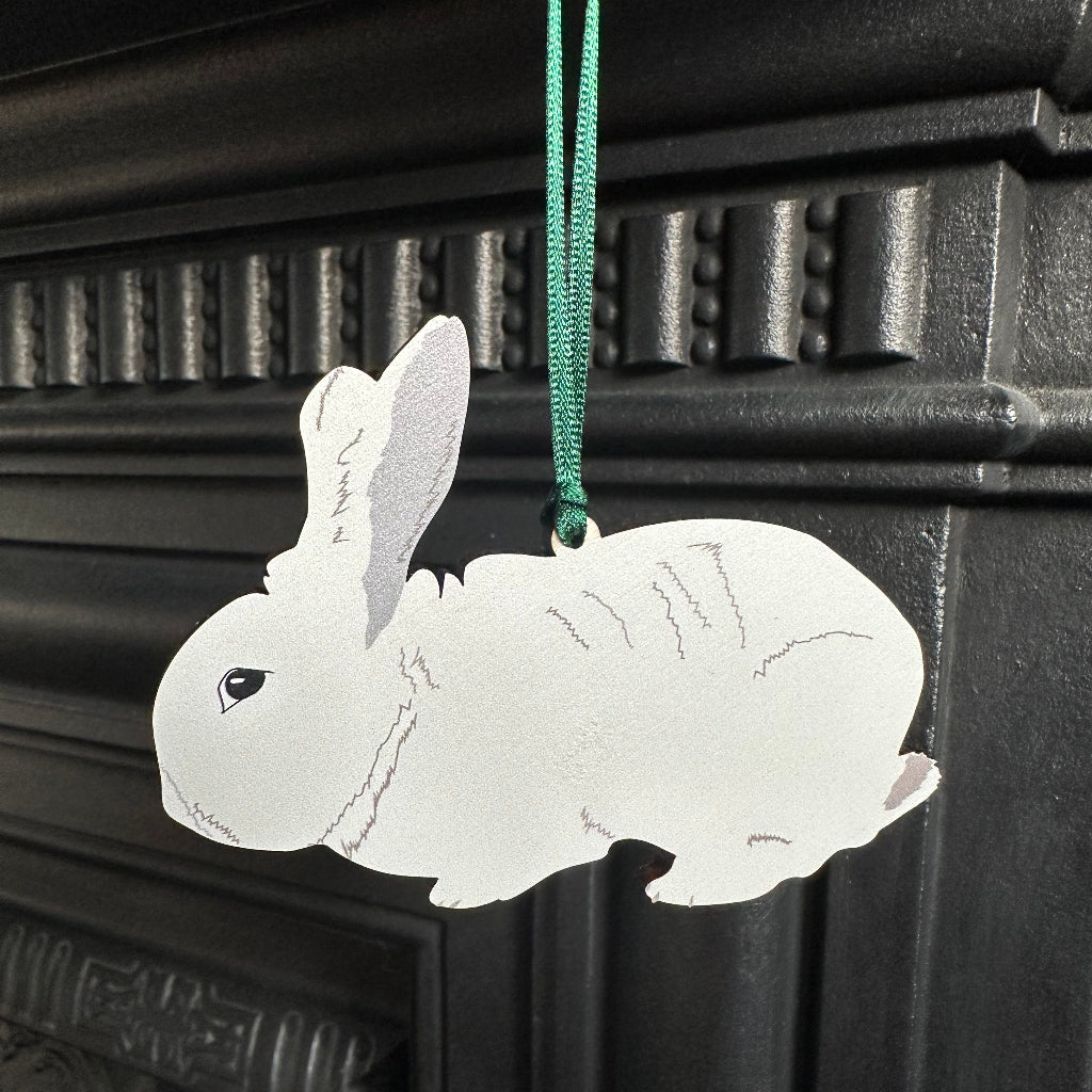 wooden rabbit hanging ornament shown hanging from a fireplace