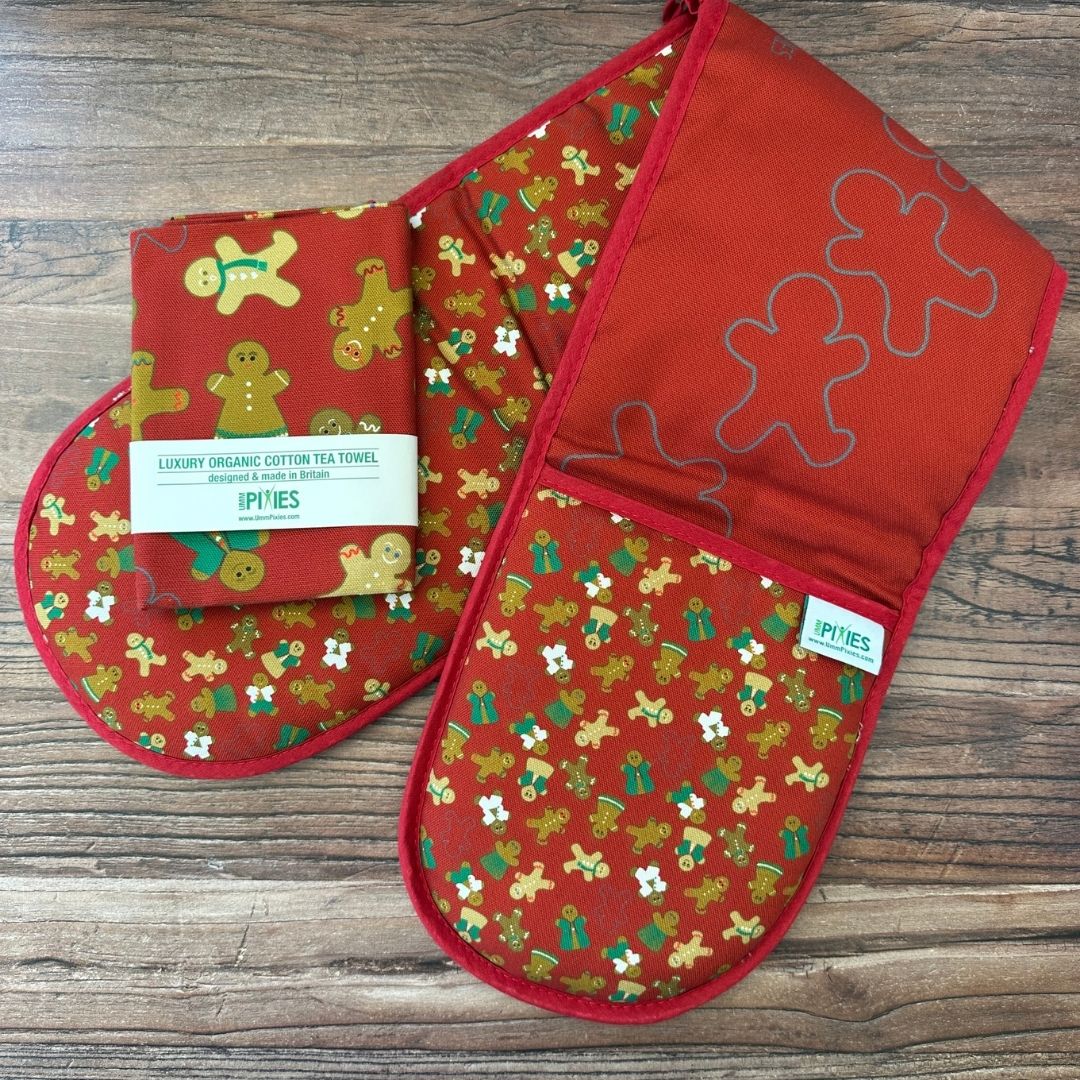Gingerbread Folk Organic cotton oven gloves and matching tea towel on a wooden countertop