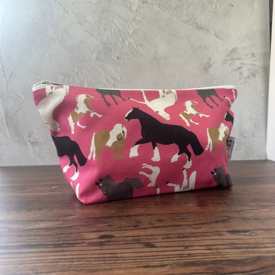 Pink Horses illustrated really useful bag shown zipped closed on wooden surface