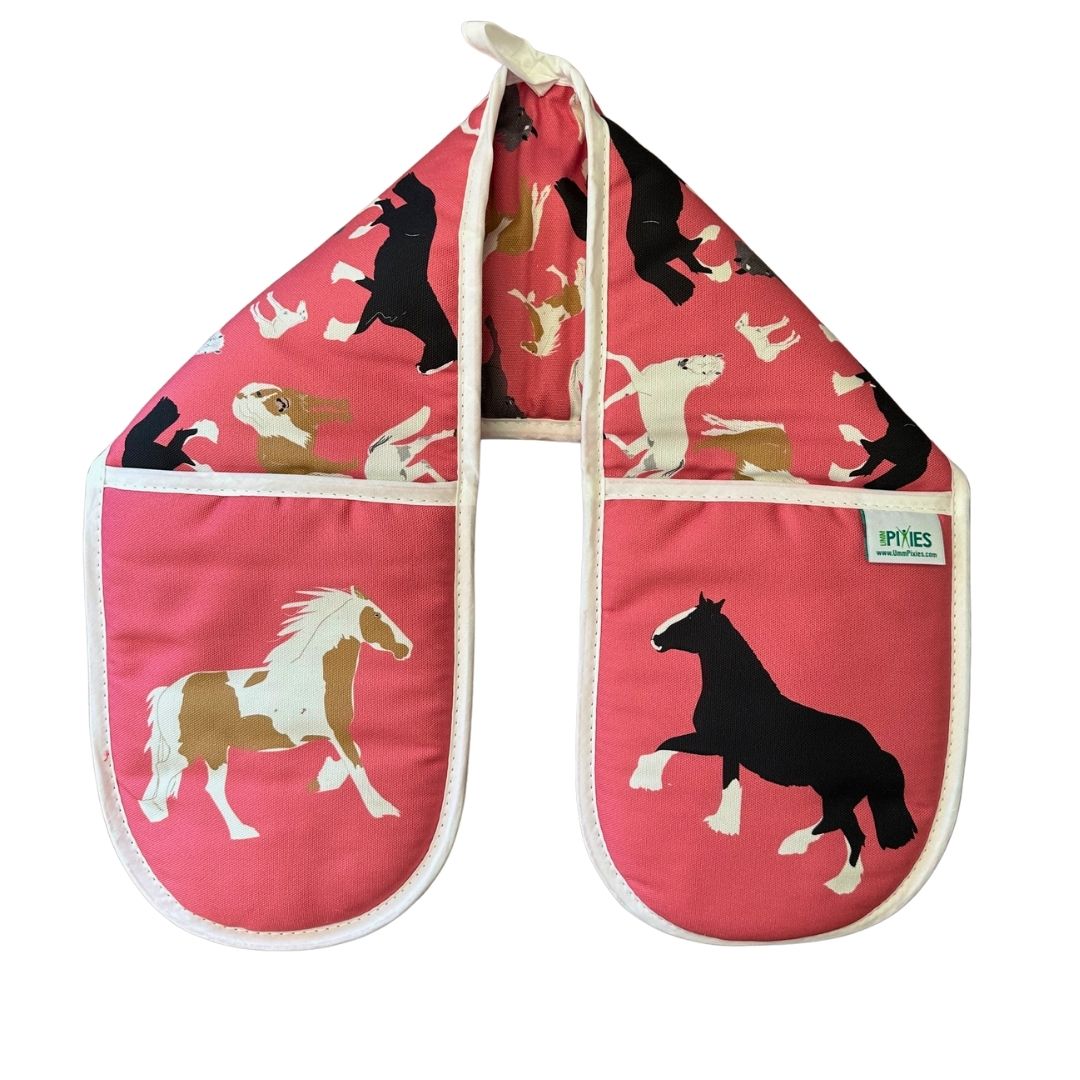 Pair of oven mitts with horse designs on a pink background