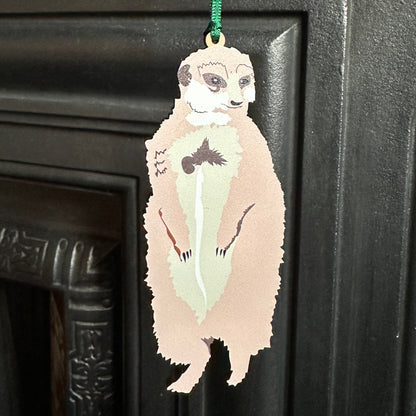 Sentry meerkat wooden hanging decoration shown hanging from corner of a cast iron fireplace