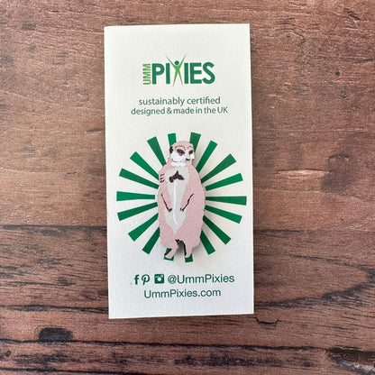 Meerkat wooden pin badge on display card on wooden table