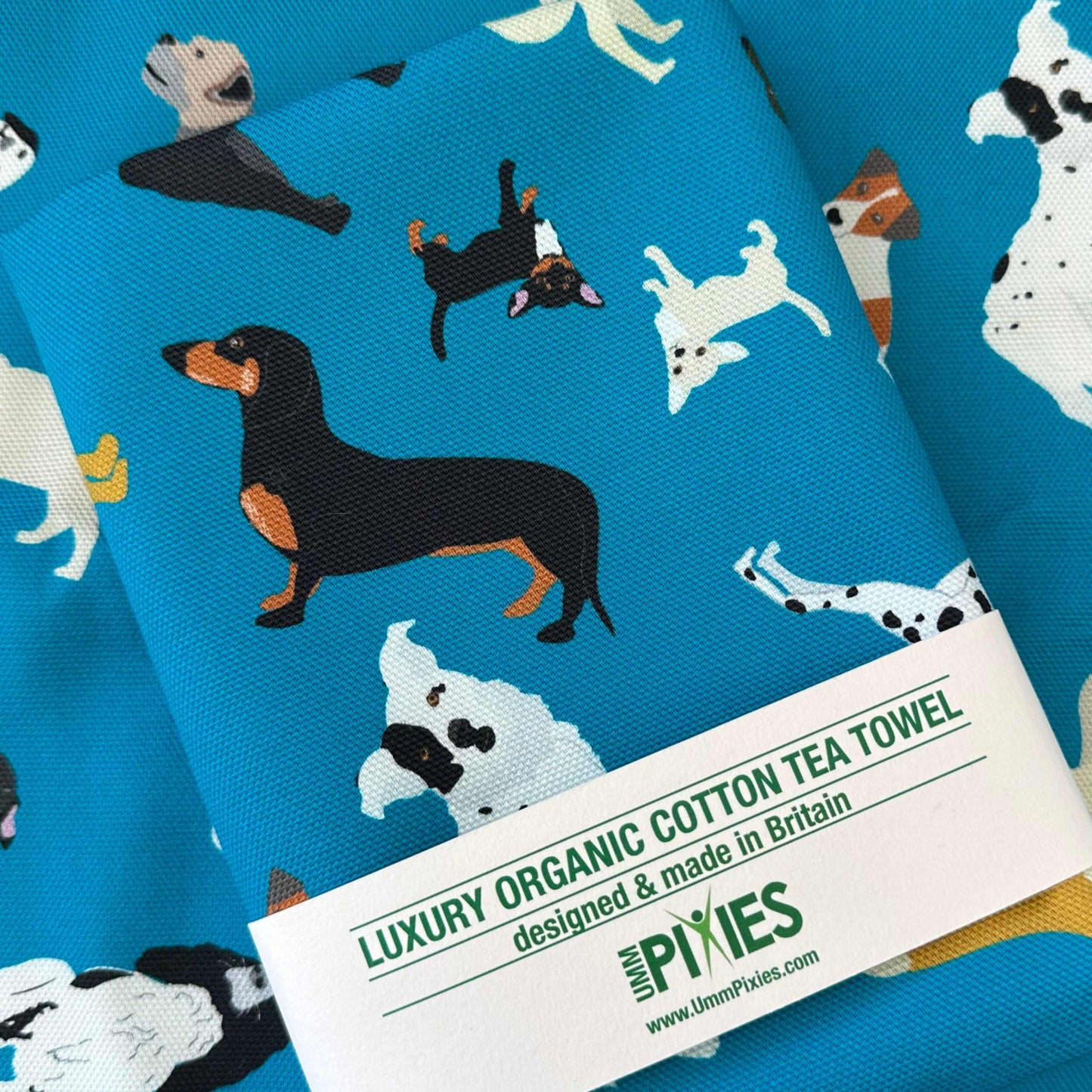 Tea towel with dog pattern shown in recycled packaging