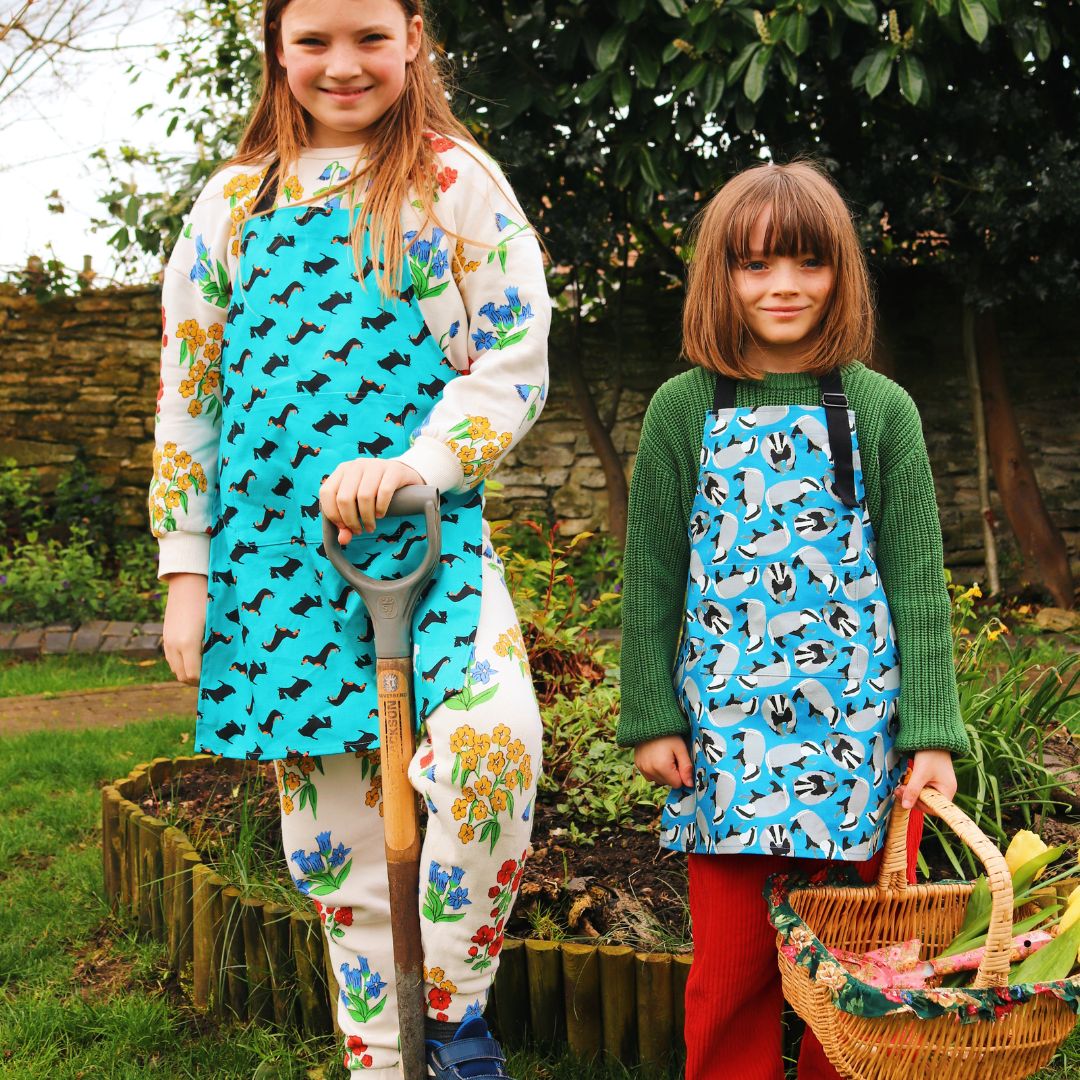 Older child wear dogtooth dogs apron (6-12yrs) younger child wears badgers apron (up to 5 yrs) while gardening  Photo credit @rachelandthelittlebirds