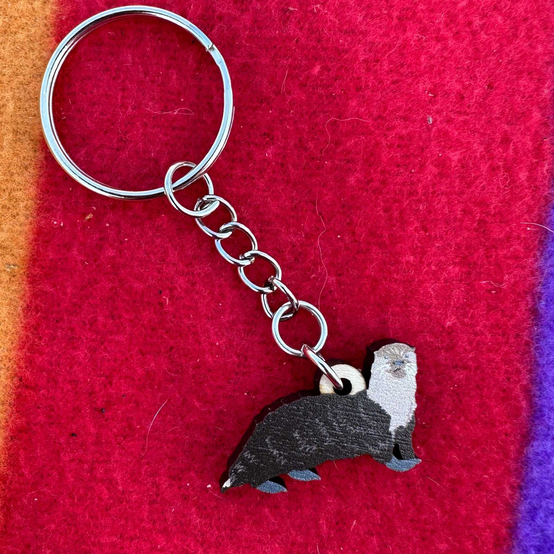 Keychain with an otter design on a red fabric background