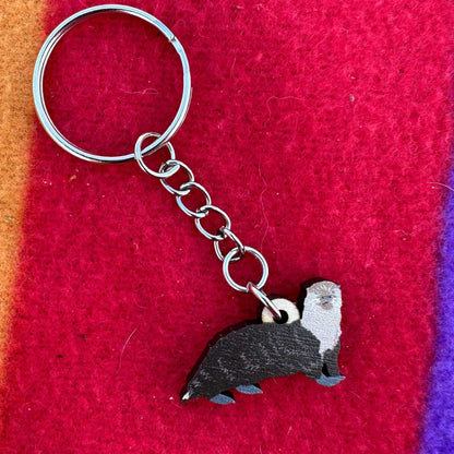 Keychain with an otter design on a red fabric background