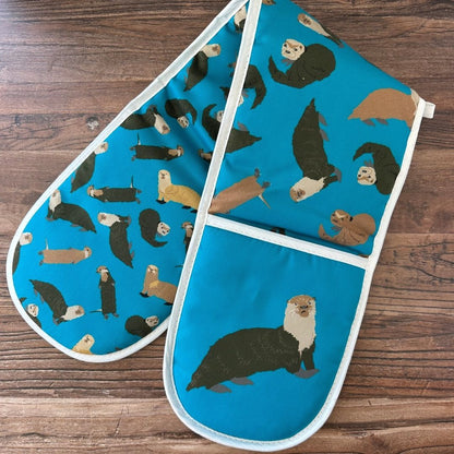 Oven mitt with otter pattern on a wooden surface