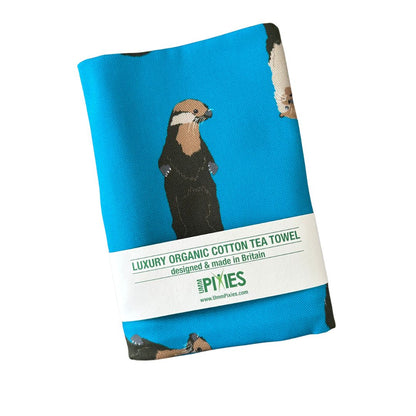 Petrol blue otters design organic cotton tea towel shown in packaging 