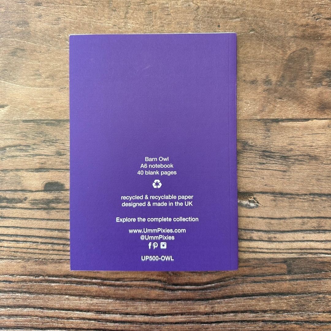 Purple notebook on a wooden surface with text about the product.