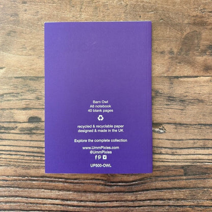 Purple notebook on a wooden surface with text about the product.