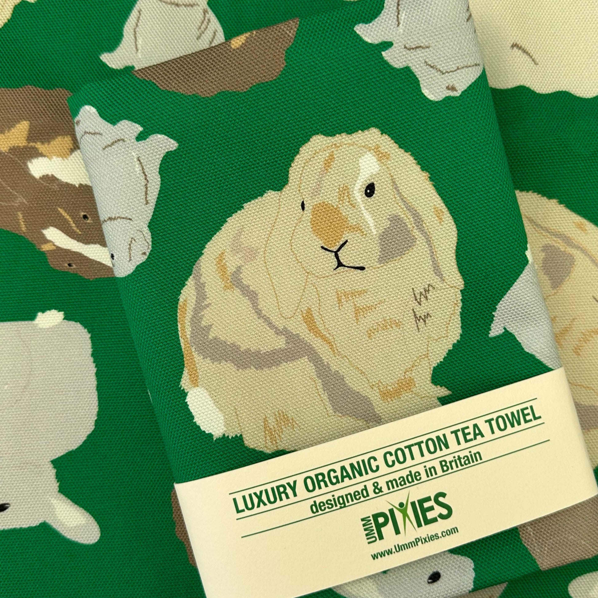 Luxury organic cotton tea towel with a rabbit design on a green background.