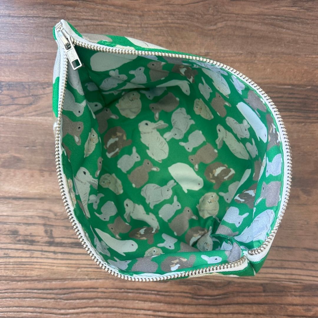 overhead view showing zip open and the printed waterproof lining with rabbits illustrations