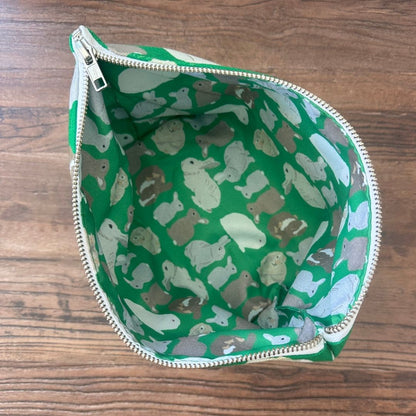 overhead view showing zip open and the printed waterproof lining with rabbits illustrations