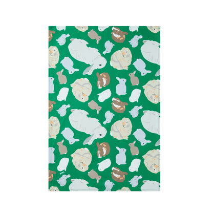 Green cotton kitchen towel with rabbits design shown laying flat on a white background