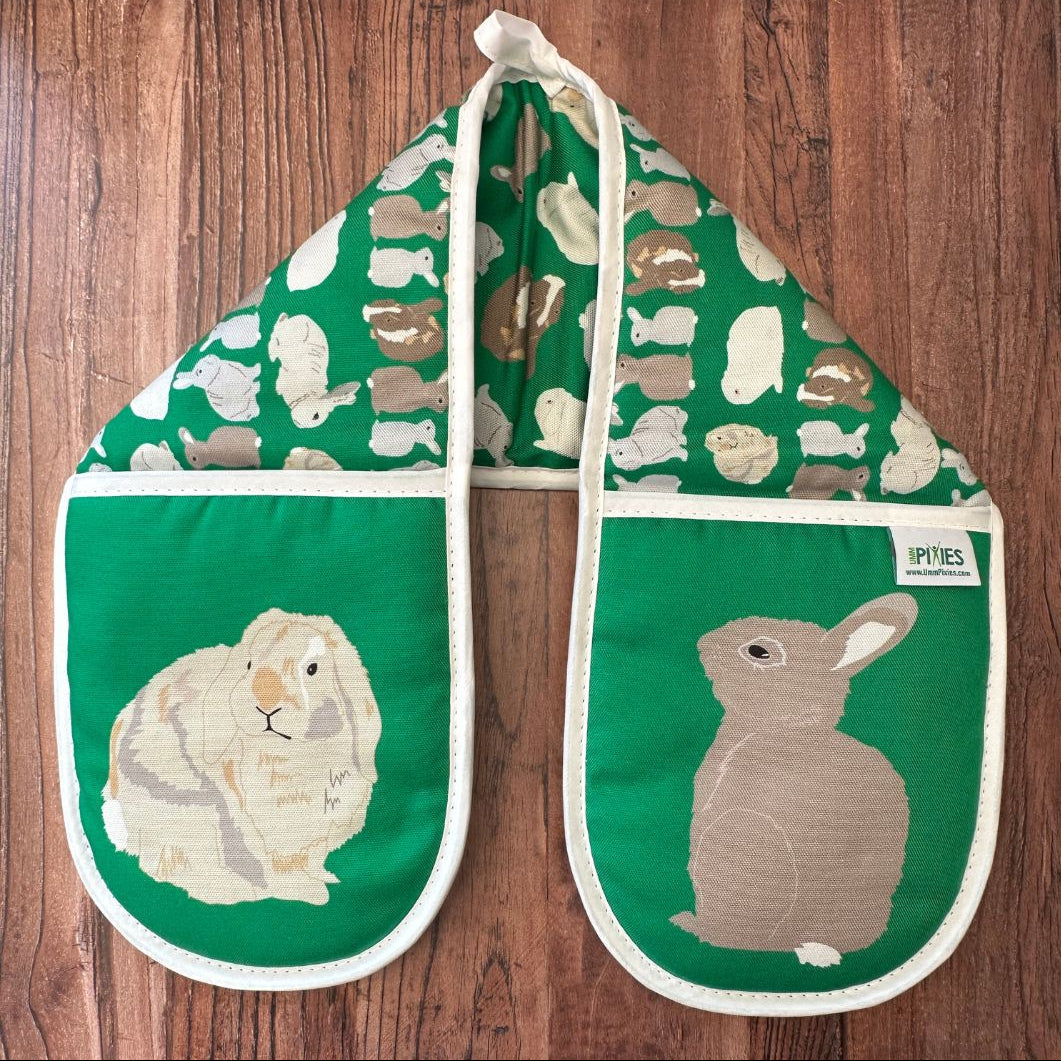 Bright Green Rabbits design organic cotton Oven Mitts on a wooden counter