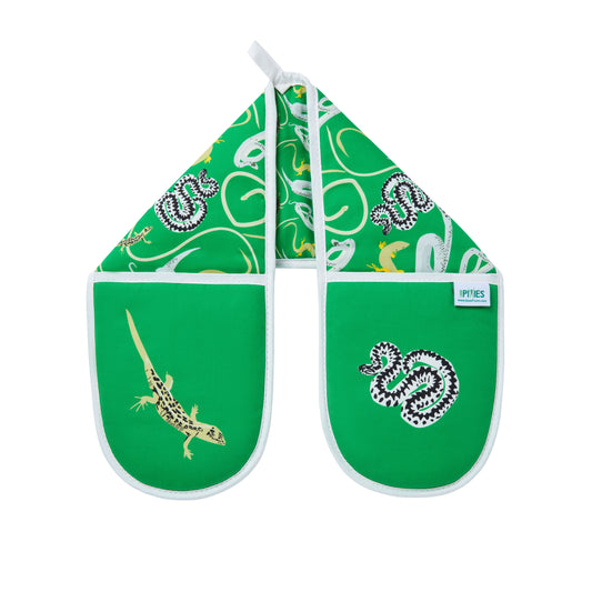 Green oven mitts with snakes and lizards patterns on a wooden surface