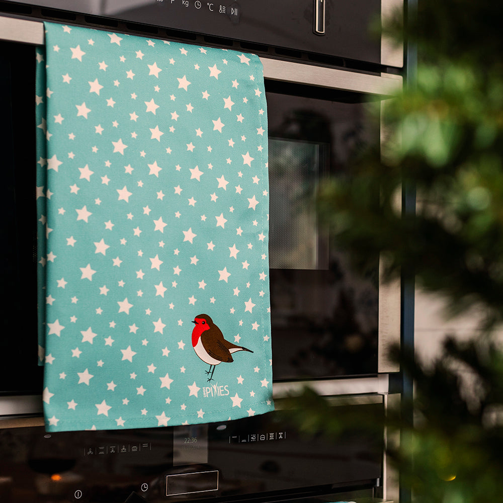 Robin and Stars tea towel shown on oven door