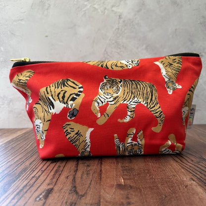 Bright Red Sumatran Tiger illustrations of this  really useful bag shown with zip closed on a wooden counter