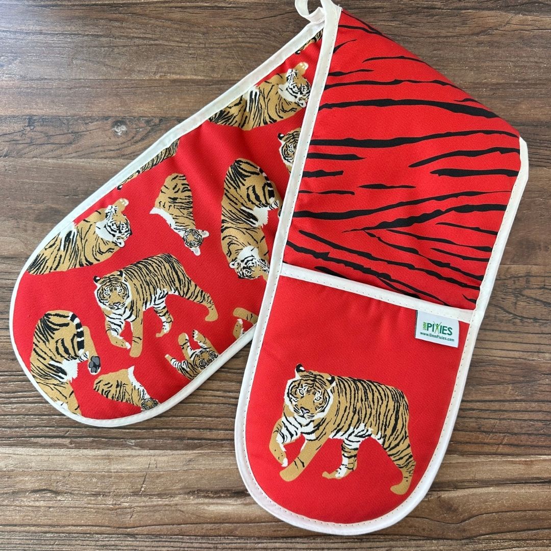 Red Tigers design organic cotton oven gloves on wooden surface